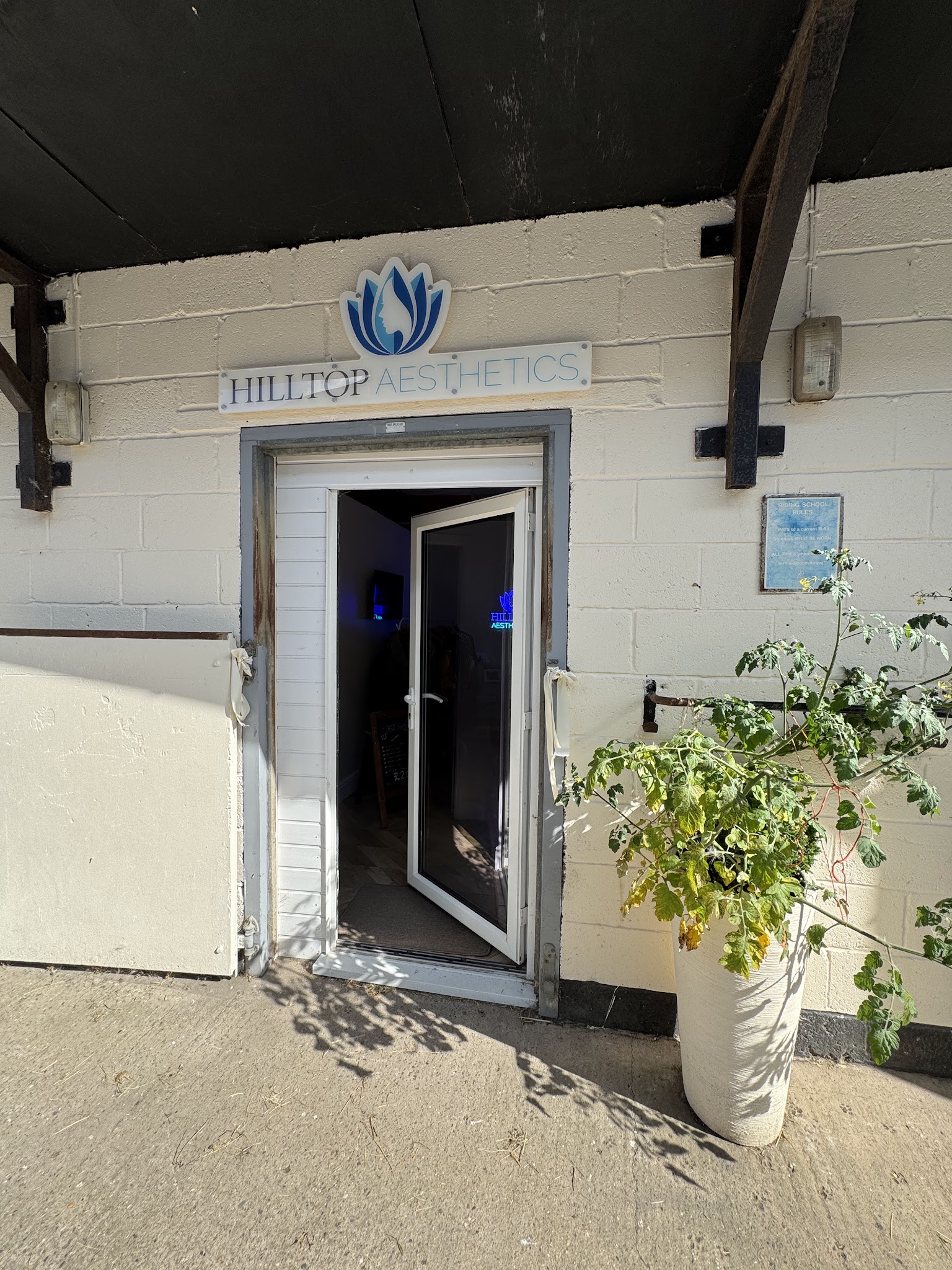 Hilltop Aesthetics sign above the clinic entrance.